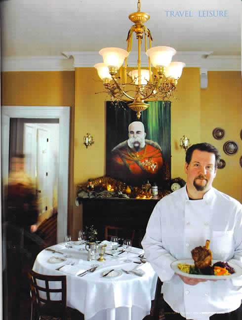 Jonathan S. Krach holding Vienna restaurant house specialty wild boar shank